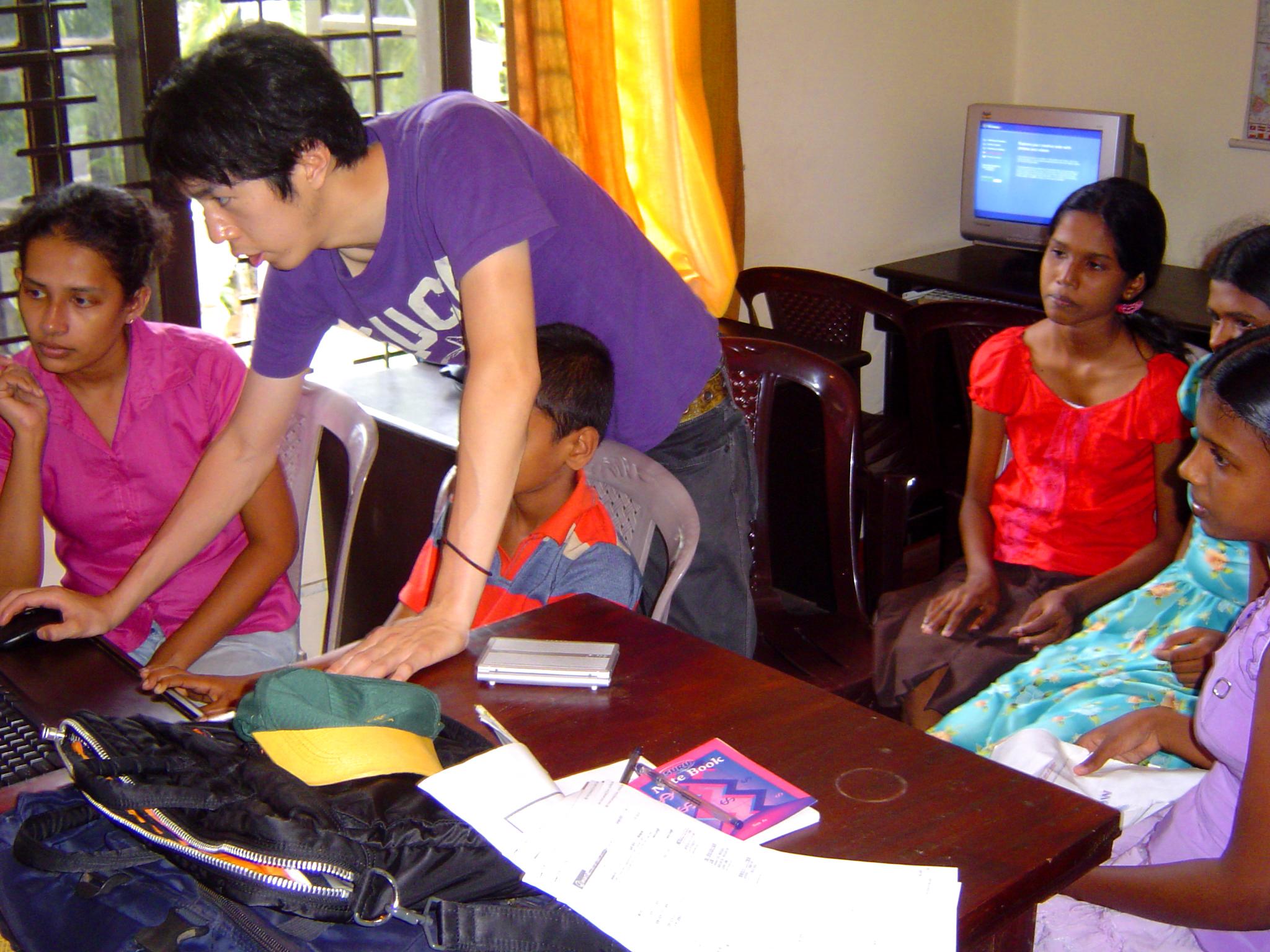 Projects Abroad volunteer teaching IT in Sri Lanka with a group of students at a local IT centre. A group of students with a volunteer doing a teaching IT placement in Sri Lanka.